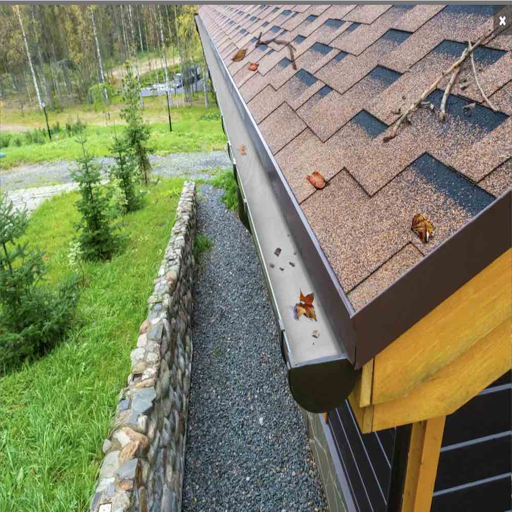 Aluminum gutter guard mesh fitted along a house gutter